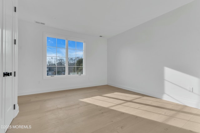 empty room with visible vents, baseboards, and light wood-style floors