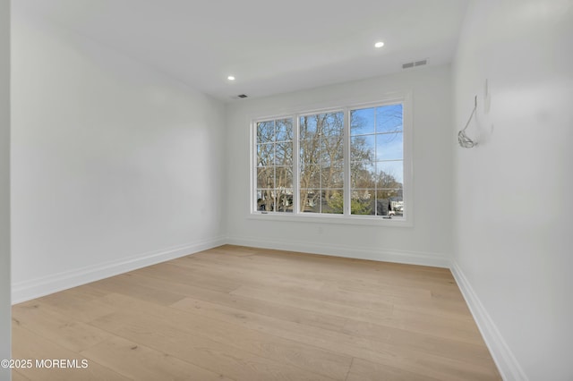 empty room with light wood-type flooring, visible vents, baseboards, and recessed lighting