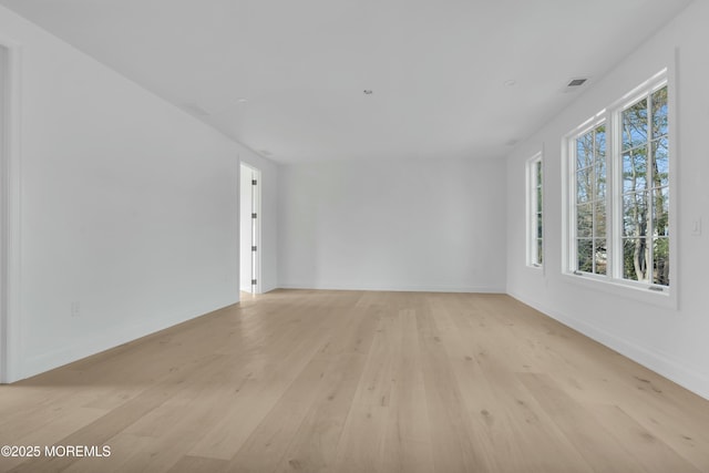 unfurnished room featuring visible vents, baseboards, and light wood finished floors