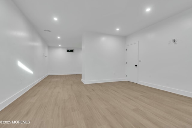 finished basement featuring visible vents, recessed lighting, light wood-type flooring, and baseboards