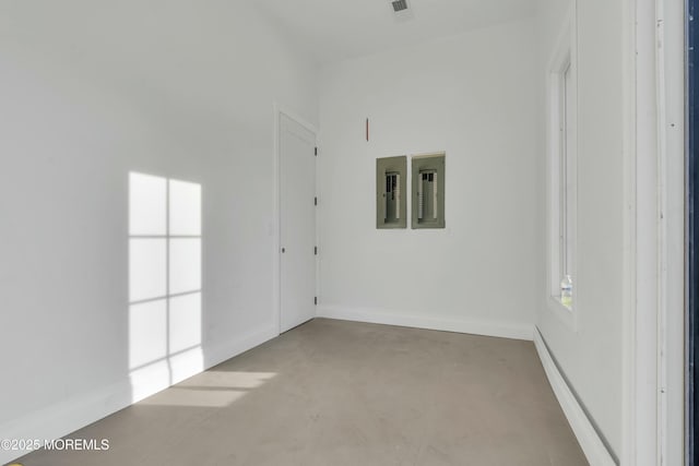 unfurnished room featuring concrete floors and baseboards