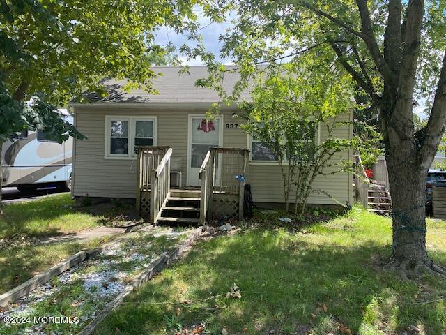 view of front of home featuring stairs, a front yard, and a deck