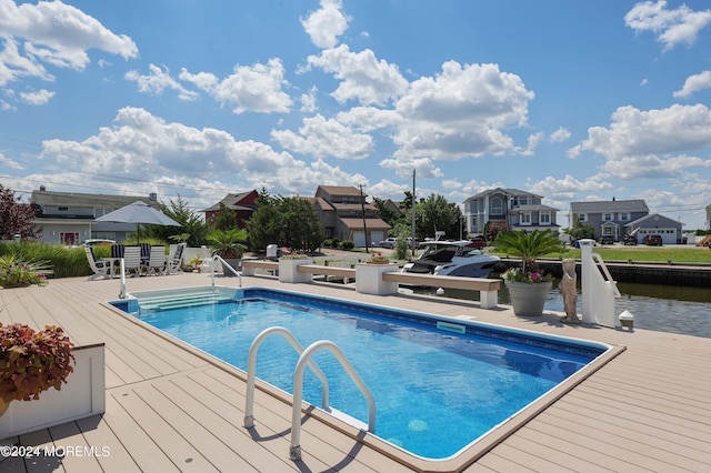 outdoor pool with a water view and a residential view