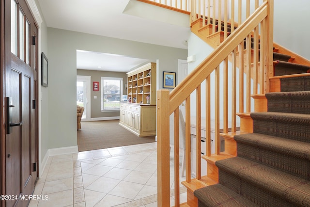 stairway featuring tile patterned flooring and baseboards