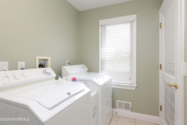 laundry room featuring light tile patterned floors, visible vents, separate washer and dryer, laundry area, and baseboards