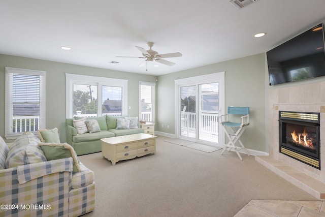 living room featuring recessed lighting, light colored carpet, visible vents, a tile fireplace, and baseboards