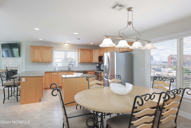 dining area featuring light tile patterned floors, recessed lighting, visible vents, a view of city, and a tiled fireplace