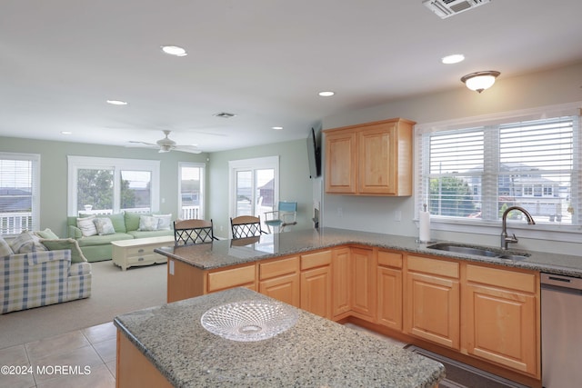 kitchen featuring visible vents, dishwasher, a kitchen island, open floor plan, and a sink