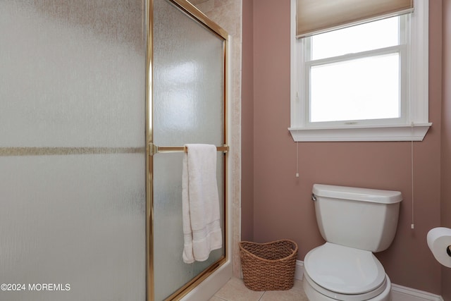 bathroom with baseboards, a stall shower, toilet, and tile patterned floors