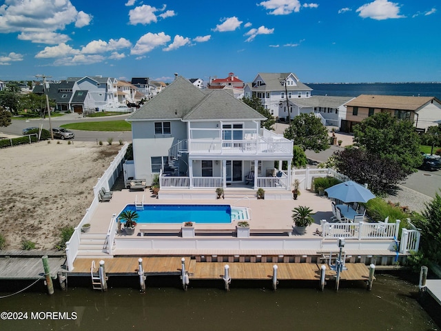 back of property featuring a fenced in pool, a patio, a fenced backyard, a residential view, and a water view