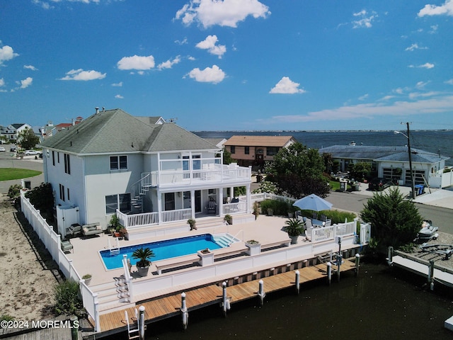 back of house featuring a fenced in pool, a patio, a balcony, a fenced backyard, and stairs