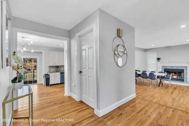 hall featuring a notable chandelier and light wood-type flooring