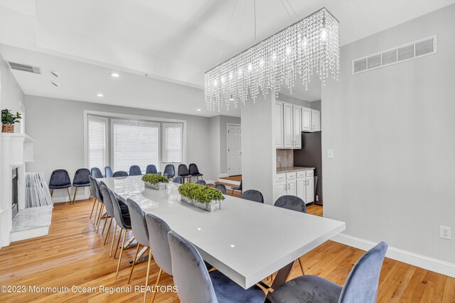 dining space with a chandelier and light hardwood / wood-style floors