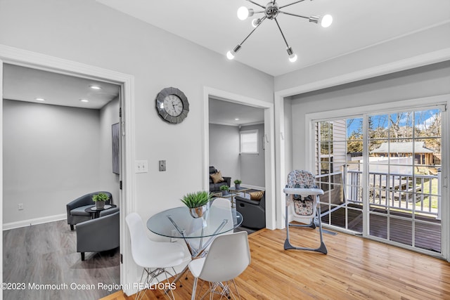 dining area with hardwood / wood-style flooring and a chandelier