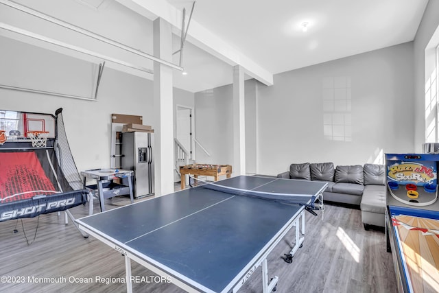 game room with hardwood / wood-style flooring and beam ceiling