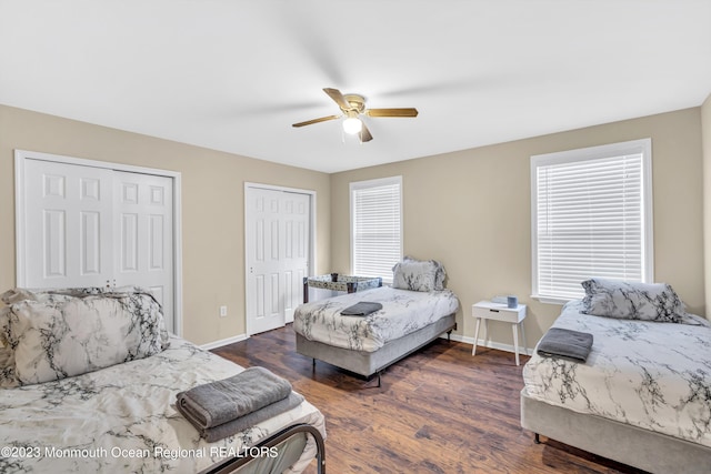 bedroom featuring multiple closets, ceiling fan, and dark hardwood / wood-style flooring