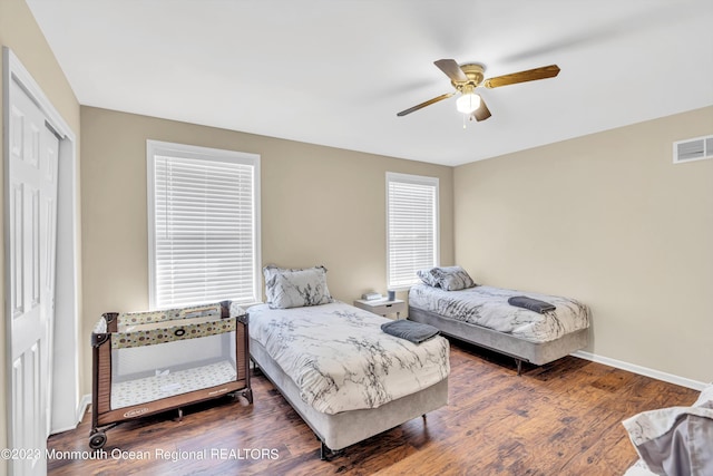 bedroom featuring dark wood-type flooring, a closet, and ceiling fan