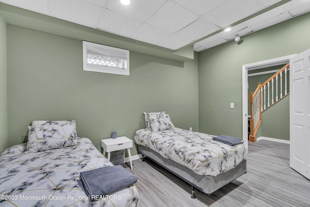 bedroom with hardwood / wood-style flooring and a drop ceiling