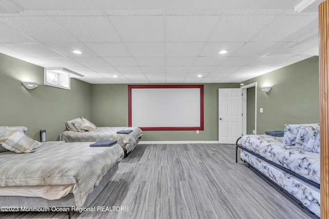 bedroom with wood-type flooring and a drop ceiling