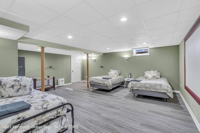 bedroom featuring a drop ceiling and hardwood / wood-style floors