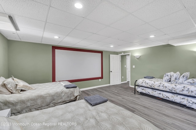 bedroom with hardwood / wood-style floors and a paneled ceiling