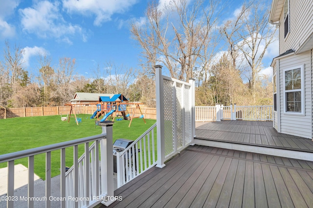 wooden deck with a yard and a playground