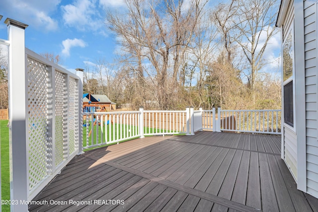 deck featuring a playground and a lawn