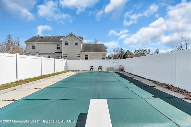 view of swimming pool with a diving board