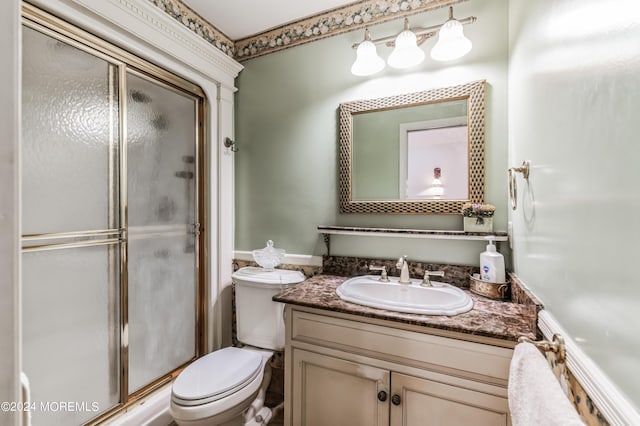 full bath featuring vanity, toilet, and an enclosed shower