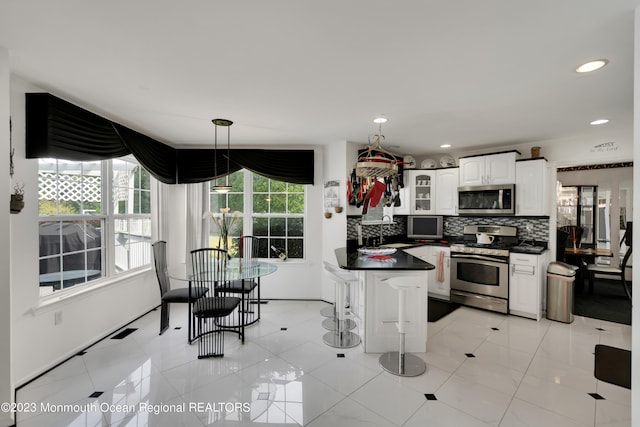 1969 Whitesville Rd, Toms River, NJ 08755 - kitchen with a breakfast bar, stainless steel appliances, plenty of natural light, and white cabinetry