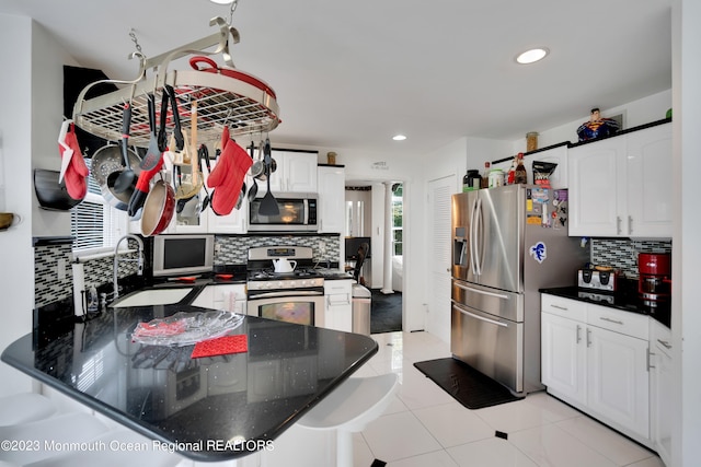 1969 Whitesville Rd, Toms River, NJ 08755 - kitchen featuring stainless steel appliances, white cabinetry, light tile patterned floors, and a healthy amount of sunlight