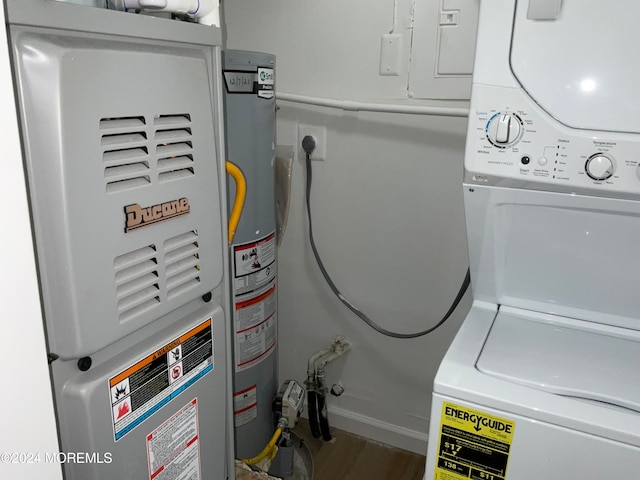 laundry area featuring hardwood / wood-style flooring, gas water heater, heating unit, and stacked washing maching and dryer