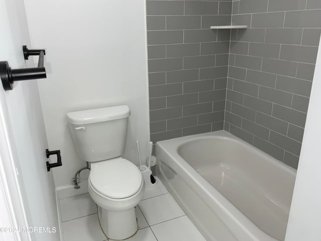 bathroom with toilet, tiled shower / bath, and tile patterned flooring