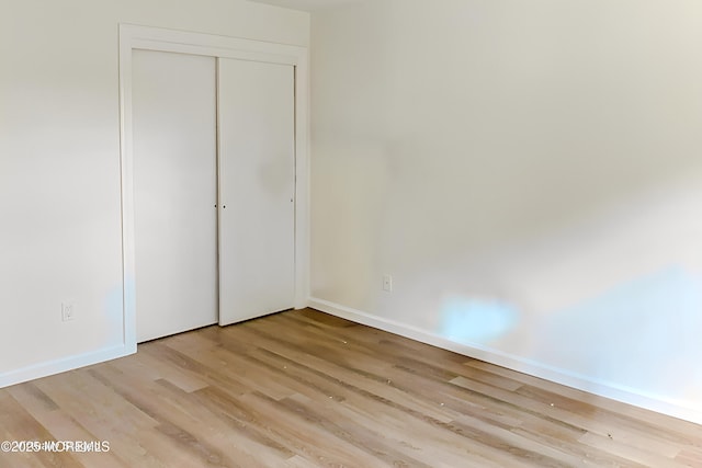 unfurnished bedroom featuring a closet and light hardwood / wood-style floors