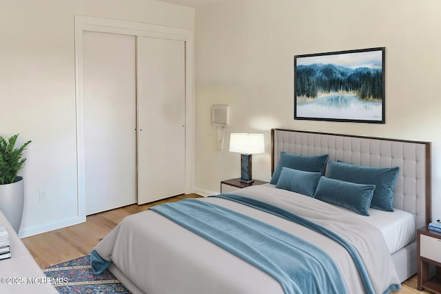 bedroom with light wood-type flooring and a closet