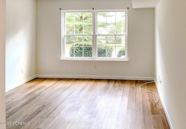 unfurnished room with a healthy amount of sunlight and light hardwood / wood-style floors