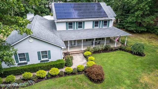 view of front of property with a shingled roof, a chimney, and a front yard