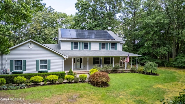 view of front of property featuring a front lawn, a porch, and roof mounted solar panels