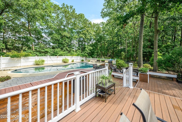 wooden deck with a fenced backyard and a fenced in pool