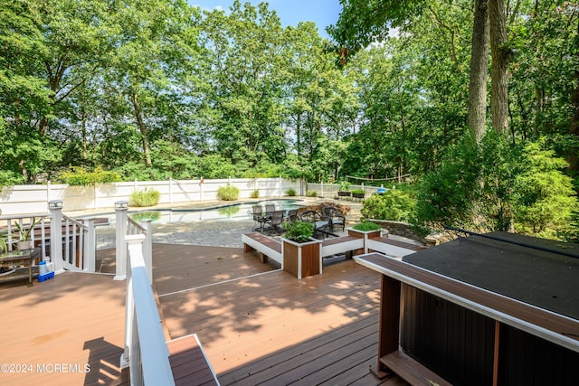 wooden deck with a fenced backyard and a fenced in pool