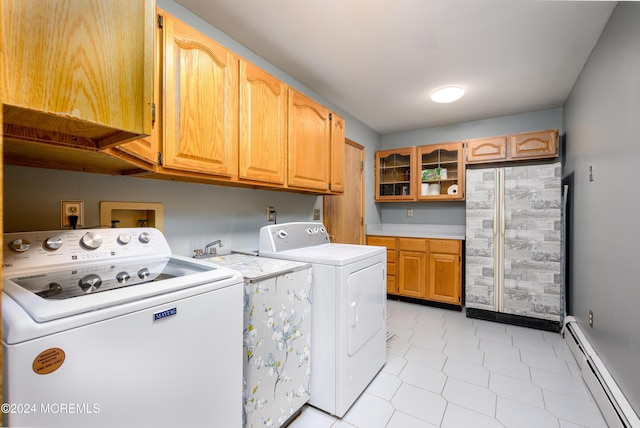 washroom featuring cabinet space, baseboard heating, and washer and dryer