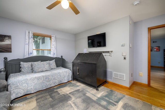 living area with baseboards, visible vents, ceiling fan, and wood finished floors