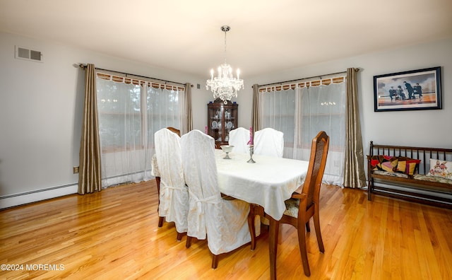 dining room with a notable chandelier, baseboard heating, visible vents, and light wood-style floors