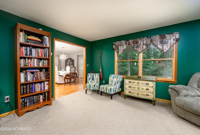 sitting room with an inviting chandelier, baseboards, and carpet flooring