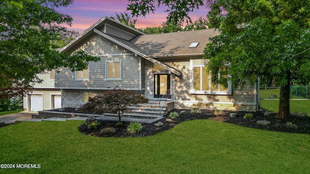 view of front of house with a garage and a yard