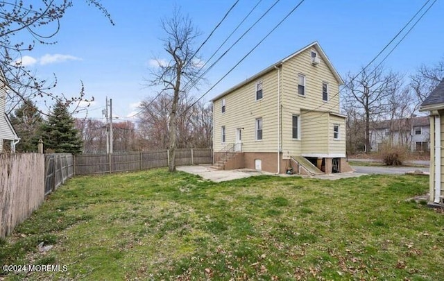 back of property with a yard and a patio