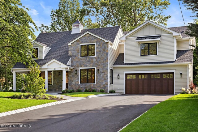 view of front of home with a front yard and a garage