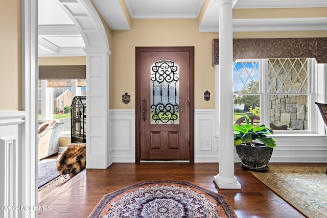 foyer entrance with dark hardwood / wood-style flooring, crown molding, and decorative columns