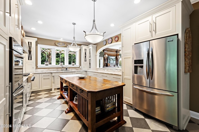 kitchen featuring white cabinetry, stainless steel fridge, sink, and light stone countertops