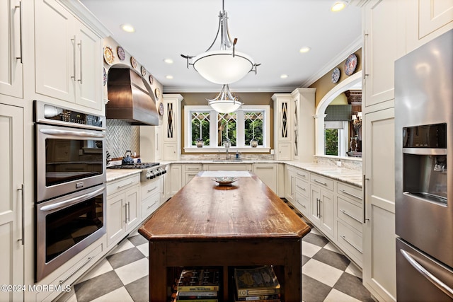 kitchen featuring backsplash, premium range hood, light tile patterned floors, a center island, and stainless steel appliances